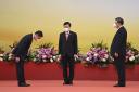 Hong Kong's new Secretary for Innovation, Technology and Industry Sun Dong, left, bows as China's President Xi Jinping, right, and Hong Kong's new Chief Executive John Lee, left, look on, during a ceremony to inaugurate the city's new