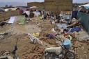 People salvage usable items from their house that was damaged by heavy rain, on the outskirts of Quetta, Pakistan, Tuesday, July 5, 2022. At least six people, including women and children, were killed when the roofs of their homes collapsed in heavy