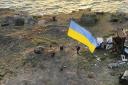 In this photo provided by the Ukrainian Defence Ministry Press Office on Thursday, July 7, 2022, Ukrainian soldiers install the state flag on Snake island, in the Black Sea. The Ukrainian military returned the flag of Ukraine to island, which had been