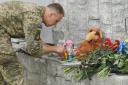 A Ukrainian serviceman lights a candle at the site of a Russian attack on Vinnytsia on Thursday which killed at least 23 people