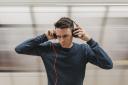 A man listening to music on his headphones. Credit: Canva