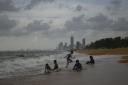 The Colombo skyline is seen as kids play on the beach