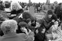 Frightened mourners take shelter behind gravestones in Milltown Cemetery, Belfast, on March 16, 1988 during the bloody assault by Michael Stone