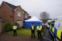 Officers from Police Scotland stand beside by police tape and a police tent outside the home of former chief executive of the Scottish National Party (SNP) Peter Murrell, in Uddingston, Glasgow