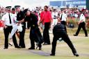 Tiger Woods walks on to the 18th green  as police try to remove the dye thrown by Fathers For Justice protesters at The Open in Hoylake in 2006