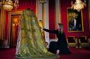 Caroline de Guitaut, deputy surveyor of the King's Works of Art for the Royal Collection Trust, adjusts the Imperial Mantle, which forms part of the Coronation Vestments, in the Throne Room at Buckingham Palace. The vestments will be worn by King Charles