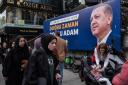 ISTANBUL, TURKEY - MAY 03: People walk past a picture of Turkish President Tayyip Erdogan in a busy shopping district on May 03, 2023 in Istanbul, Turkey. Persistently high inflation has led to a cost-of-living crisis in Turkey that has hurt President