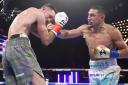 Teofimo Lopez  strikes Josh Taylor in their world title fight in New York