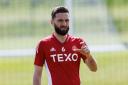Graeme Shinnie has signed a three-year deal with Aberdeen after leaving Wigan Athletic
