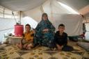 Shahinaz and her grandsons sit in their tent at a camp in north-west Syria on 22 June 2023