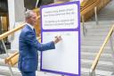 LibDem MSP Liam McArthur signing a pledge card in support of his Assisted Dying Bill at the Scottish Parliament in Holyrood