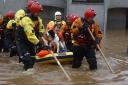 Members of the coastguard rescue team wade through the flood waters to evacuate a man and a dog on October 20, 2023 in Brechin, Scotland