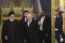 Russian President Vladimir Putin welcomes Iranian President Ebrahim Raisi, left, for talks at the Kremlin