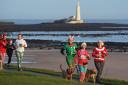 Runners dressed in festive outifits take part in the Christmas Eve park run at Whitley Bay in the North East of England