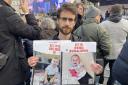 Eylon Keshet, 30, holding a photo of his cousin's children who were taken hostage alongside their parents on October 7 during a pro-Israel rally in Trafalgar Square, London last Sunday.