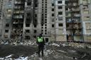 A policeman stands in front of a heavily damaged residential building, three days after a Russian missile attack in Kyiv, on January 5, 2024, amid the Russian invasion of Ukraine.