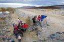 Migrants place clothing atop razor wire  to cross the border into El Paso, Texas from Ciudad Juarez, Mexico.