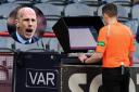 A Scottish referee looks at a replay on a pitchside monitor during a VAR check, main picture, and Philippe Clement, inset