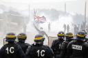 Tear gas fills the air as French riot police face off with demonstrators near the area called the 