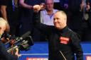John Higgins celebrates after beating Kyren Wilson 17-13 at The Crucible in Sheffield