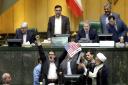 Iranian lawmakers prepare to burn two pieces of papers representing the U.S. flag and the nuclear deal as they chant slogans against the U.S. at the parliament in Tehran, Iran, Wednesday, May 9, 2018. Iranian lawmakers have set a paper U.S. flag ablaze at