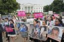 People hold up signs and photographs during a  demonstration opposed to the White House policy that separated more than 2,300 children from their parents over the past several weeks in front of the White House in Washington, Thursday, June 21, 2018. (AP P