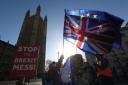 Anti-Brexit campaigners wave Union and EU flags outside the Houses of Parliament. Picture: PA