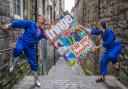 (From left) Cris Peploe, Claudia Cawthorne and Martha Haskins pose with a large-scale version of the Edinburgh Festival Fringe 2023 programme cover during the launch