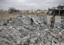 Palestinians survey the destruction after an Israeli airstrike in Khan Younis, Gaza Strip, yesterday