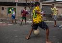 Boys play football  in the streets of the Garden Gloria neighborhood in the city of Praia Grande