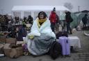 A woman covers herself with a blanket to keep warm after fleeing from the Ukraine and arriving at the border crossing in Medyka, Poland, today. Photo Markus Schreiber/AP