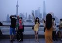 Residents pose for photos along the bund, Wednesday, June 1, 2022, in Shanghai. Traffic, pedestrians and joggers reappeared on the streets of Shanghai on Wednesday as China's largest city began returning to normalcy amid the easing of a strict
