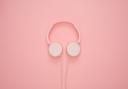 Headphones on a pink background. Credit: Canva