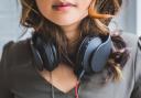 A woman listening to music on her headphones. Credit: Canva