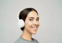 A woman listening to music on her headphones. Credit: Canva