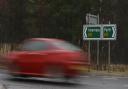 A car passes a sign on the A9 near Dalnamein, Perthshire.