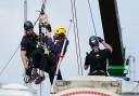 Police remove protesters (in yellow helmets) from This Is Rigged as they sit on top of an oil tanker at the Ineos refinery in Grangemouth