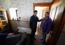 First Minister Humza Yousaf with Kim Clark as she shows him the mess inside her home following the floods during a visit to River Street in Brechin
