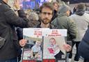 Eylon Keshet, 30, holding a photo of his cousin's children who were taken hostage alongside their parents on October 7 during a pro-Israel rally in Trafalgar Square, London last Sunday.