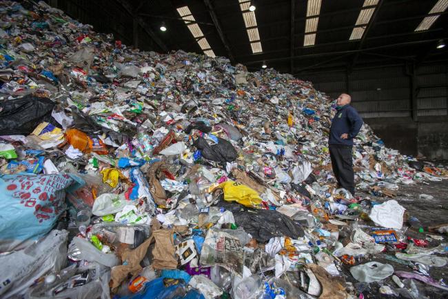 Andy Gordon, supervisor at Glasgow City Council's Blochairn recycling facility in Glasgow, looking at a mound of items that people have put into blue bin items for recycling  Picture: Colin Mearns