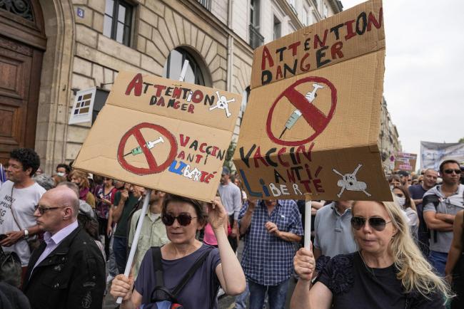 Anti-vaccine protesters hold placards that read attention danger vaccine anti-liberty during a rally in Paris, Saturday,  (AP Photo/Michel Euler).