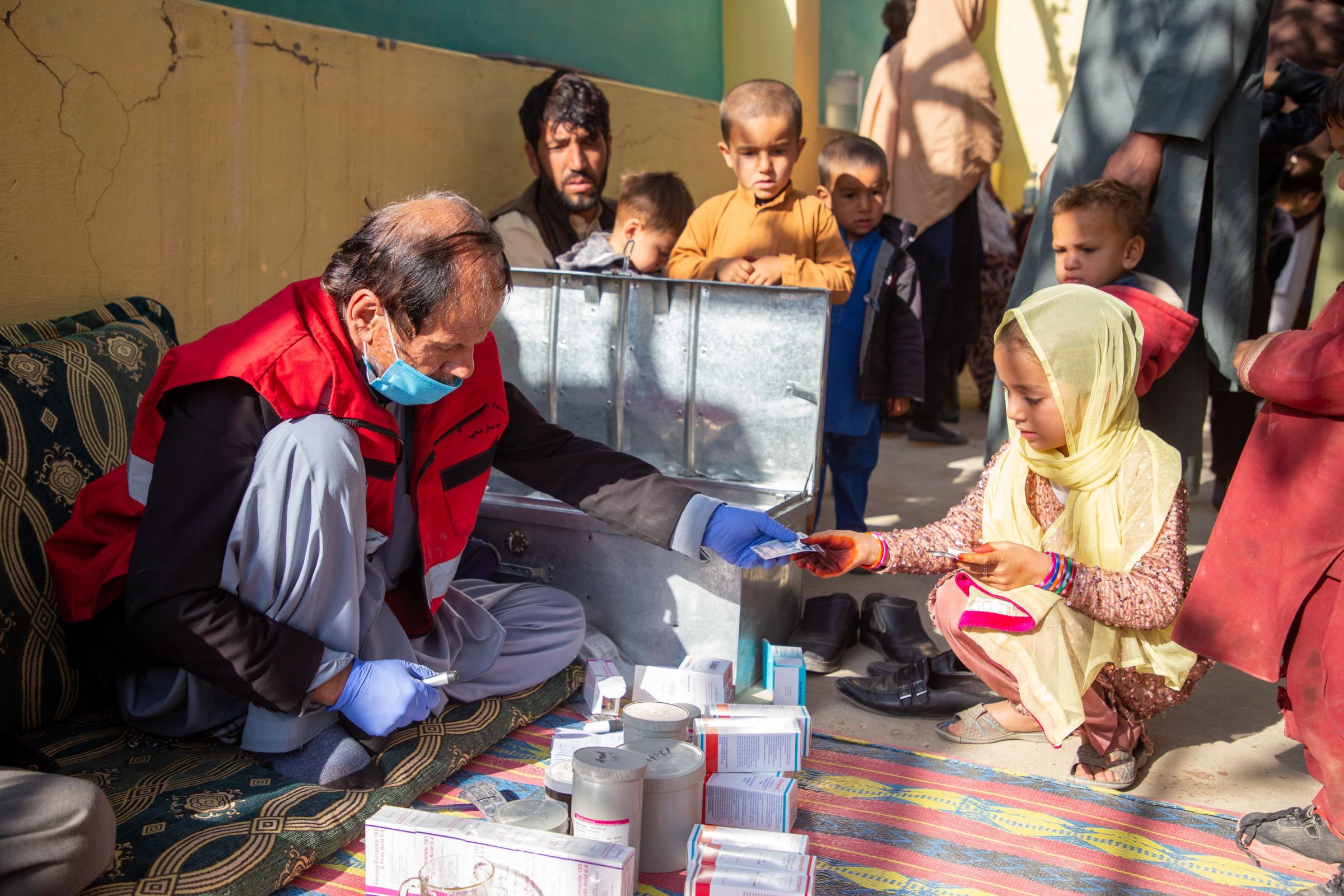 A pharmacist from one of the Afghan Red Crescents mobile health teams providing much-needed medicines during a community visit. 
