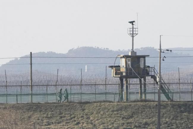 South Korean army soldiers patrol along the barbed-wire fence in Paju, near the border with North Korea, South Korea, Sunday, Jan. 2, 2022. South Korea's military said Sunday that an unidentified person crossed the heavily fortified border into North