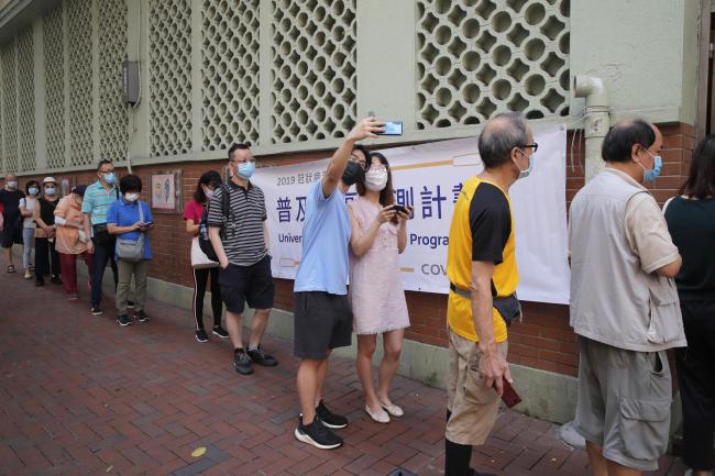People wearing face masks queue for the coronavirus test outside a testing center in Hong Kong, Tuesday, Sept. 1, 2020.  (AP Photo/Kin Cheung).