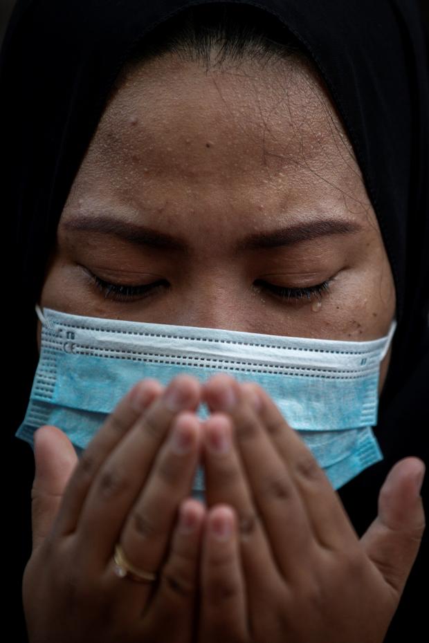HeraldScotland: A Filipino Muslim woman wearing a surgical mask prays on the morning of Eid al-Fitr outside the Manila Golden Mosque in May 2021. (Eloisa Lopez/Reuters) 