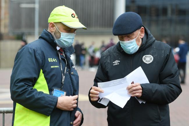 A Hearts fan has his vaccine passport checked