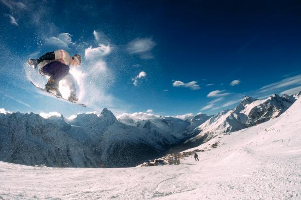 HeraldScotland: A person in the air snowboarding. Credit: Canva