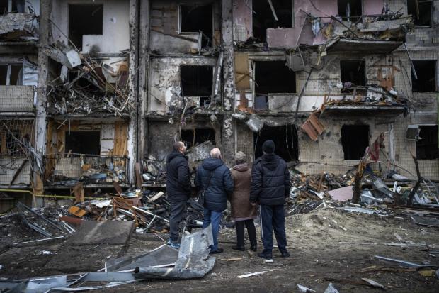 HeraldScotland: People look at the damage following a rocket attack the city of Kyiv, Ukraine, Friday, Feb. 25, 2022. (AP Photo/Emilio Morenatti)