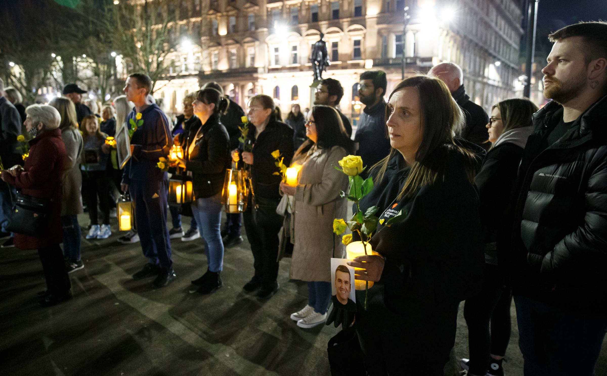 Vigil at George Square, Glasgow to mark the second national lockdown anniversary. The event attended by families who lost loved ones in the covid pandemic was organised by Covid 19 Families Scotland. Pictured are people holding lanterns and yellow roses