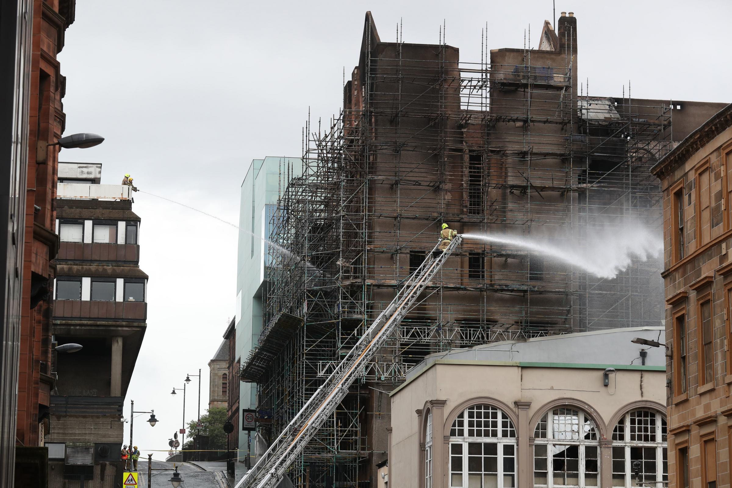 Firefighters dampening down following the fire at the Glasgow School of Art (GSA) in the historic Mackintosh Building in Glasgow in 2018.